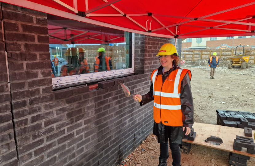 Victoria laying a brick