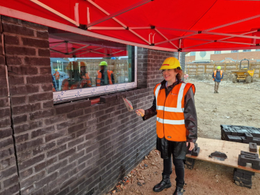 Victoria laying a brick